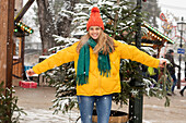 Portrait of smiling young woman standing outdoors in winter