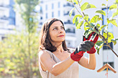 Frau beschneidet Baum im Garten