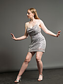 Junge Frau in Paillettenkleid tanzt