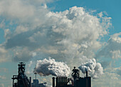 Wolken über einem Stahlwerk, die Dampf ausstoßen