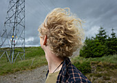 UK, Schottland, Nahaufnahme eines jungen blonden Mannes in einer Landschaft an einem windigen Tag