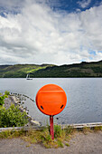 UK, Schottland, Orangefarbene Rettungsbojenbox am Seeufer