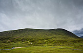 UK, Schottland, Gewitterwolken über einem grünen Hügel