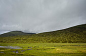 UK, Schottland, Gewitterwolken über grünen Hügeln