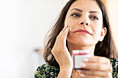 Frau verwendet Feuchtigkeitscreme für das Gesicht