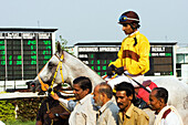 Ein Jockey auf einem Pferd auf der Rennbahn von Kalkutta während des St. Leger-Meetings im März; Kalkutta, Bundesstaat Westbengalen, Indien.