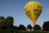 Heißluftballonstart vom Royal Victoria Park, nahe Royal Crescent, an einem Sommerabend; Bath, Somerset, England.
