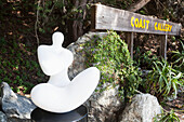Eine Skulptur neben einem hölzernen Schild für eine Küstengalerie; Kalifornien, Vereinigte Staaten von Amerika