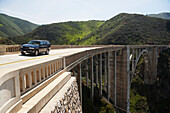 Ein Fahrzeug auf einer Hochstraße, die durch eine bergige Landschaft führt; Kalifornien, Vereinigte Staaten von Amerika