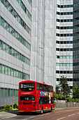 Ein roter Doppeldeckerbus auf der Straße unterhalb eines Bürogebäudes, Croydon; London, England