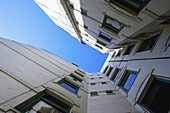 Niedriger Blickwinkel auf ein weißes Gebäude mit Fenstern und Wänden auf fünf Seiten und blauem Himmel; Hamburg, Deutschland.