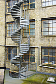 Eine gewundene Treppe an der Außenseite eines Wohngebäudes aus Backstein in Shoreditch; London, England.