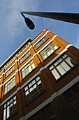 Low Angle View Of A Brown Brick Building, Street Light And Blue Sky, Shoreditch; London, England