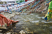 Bunte Gebetsfahnen über dem Fluss an einem Bergpass nahe der Stadt Golog; Tibet