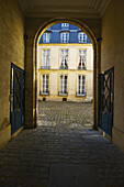 Überdachter Gehweg mit bogenförmigem Eingang und Türöffnungen, Marais-Viertel; Paris, Frankreich.