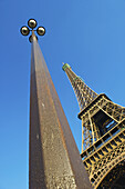Niedriger Blickwinkel auf einen Laternenpfahl und den Eiffelturm vor blauem Himmel; Paris, Frankreich