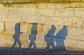 Schattenwurf von Fußgängern auf einer Mauer; Paris, Frankreich