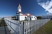 Eine Kirche mit Glockenturm und weißem Lattenzaun; Rio Grande, Argentinien