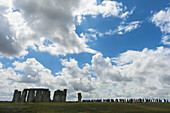 People Standing In A Row Looking Around Stonehenge; Wiltshire, England