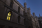 Licht aus einem Fenster eines Gebäudes auf dem alten Schulgelände in der Abenddämmerung; Cambridge, Cambridgeshire, England