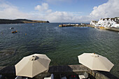 Patio With Umbrellas And A View Of The Shoreline Of Roseland Peninsula; St. Mawes, Cornwall, England