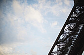 Visitors Climb One Of The Legs Of The Eiffel Tower In Paris As The Sun Sets Over The City; Paris, France