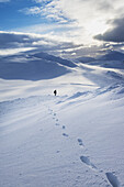 Wanderer auf verschneiter Winterwanderung, Abstieg zum Creag Pitridh, bei Laggan; Schottland.