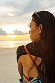 Eine junge Frau steht am Boracay Strand bei Sonnenuntergang; Boracay, Panay, Philippinen