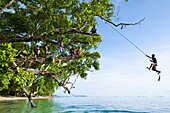 Solomon Island Boy Swinging From A Rope; Gizo, Western Province, Solomon Islands