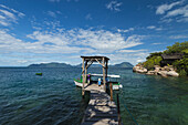 Junger Junge geht entlang des schmalen Holzstegs zum Boot vor Mumbo Island, Malawisee; Malawi