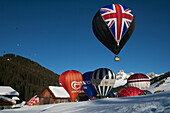 Heißluftballons, die während des jährlichen Heißluftballonfestivals des Skigebiets abheben, darunter einer mit dem britischen Union Jack; Filzmoos, Österreich