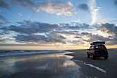 Ein Fahrzeug sitzt bei Sonnenuntergang am Casino Beach, dem längsten Strand der Welt; Rio Grande Do Sul, Brasilien.