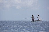 Fischer in einem Boot stehend beim Fischen; Tahiti