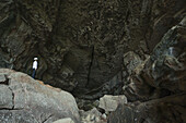 Eine Frau steht am Eingang einer großen Höhle im Toro Toro-Nationalpark; Bolivien.