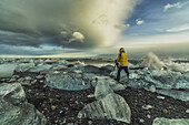Fotograf fotografiert entlang der südlichen Küste Islands mit großen Eisbrocken, die herumliegen; Island