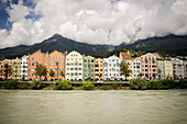Row Of Terraced Houses Nestled In The Foothills Of The Mountains; Innsbruck, Austria