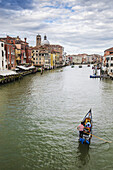 Eine Gondel fährt den Canale Grande hinunter; Venedig, Italien