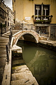 A Pedestrian Bridge Crosses The Canal; Venice, Italy