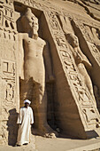 Local Man At Temple Entrance, Ramses Ii Statue (Left), Queen Nefetari Statue (Right), Hathor Temple Of Queen Nefertari, Abu Simbel Temples; Nubia, Egypt