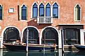 Boot an einem Gebäude mit Bogenfenstern vertäut; Venedig, Italien