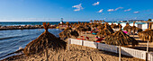 Tiki-Sonnenschirme, Strandhütten und Liegestühle am Strand Lido Paradiso in der Nähe von Trapani City; Trapani, Sizilien, Italien.