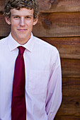 Young businessman standing against a wood wall