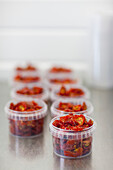 Plastic containers filled with sun dried tomatoes