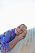 Junges Mädchen umarmt Pferd