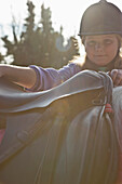 Young girl getting on a horse