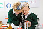 Two boys looking in a microscope