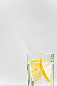 Close up of a glass of sparkling water and sliced lemon