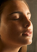 Close up of a young woman face covered in misty water