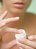 Close up of a young woman hands holding a  cream jar