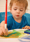 Young boy painting with watercolors